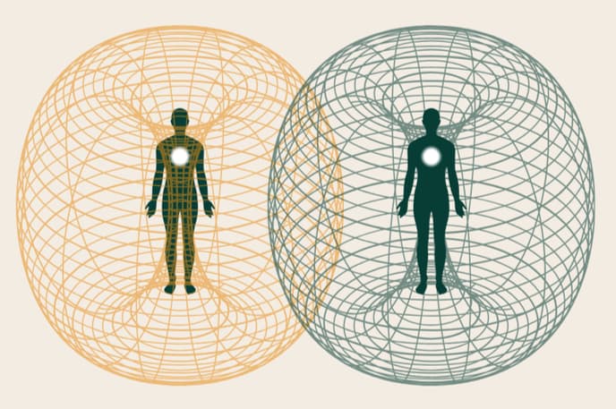 Two human figures, each within a toroidal energy field, shown side by side