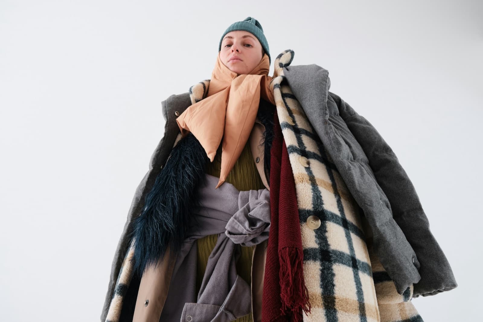 A woman wrapped in many layers of coats, scarves and a hat