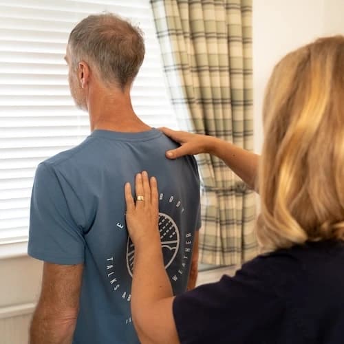 Gayle treating a patient’s shoulder
